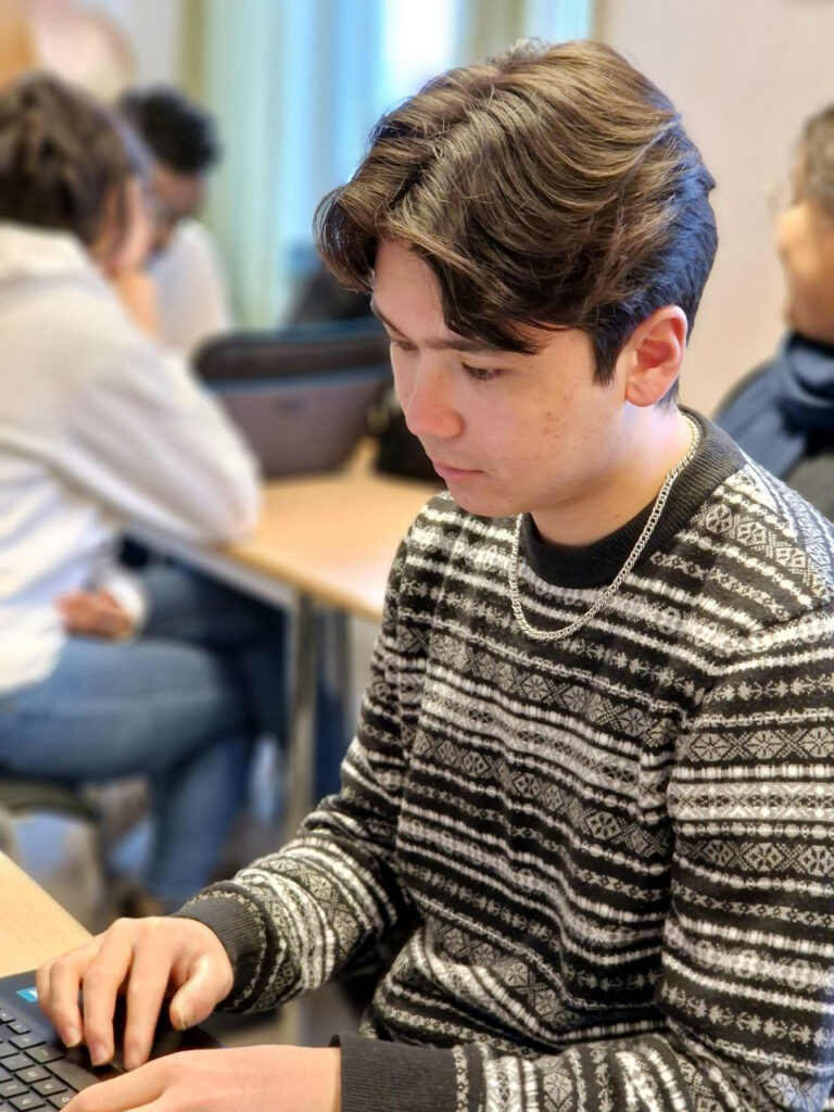 En ung kille som skriver på en dators tangentbord