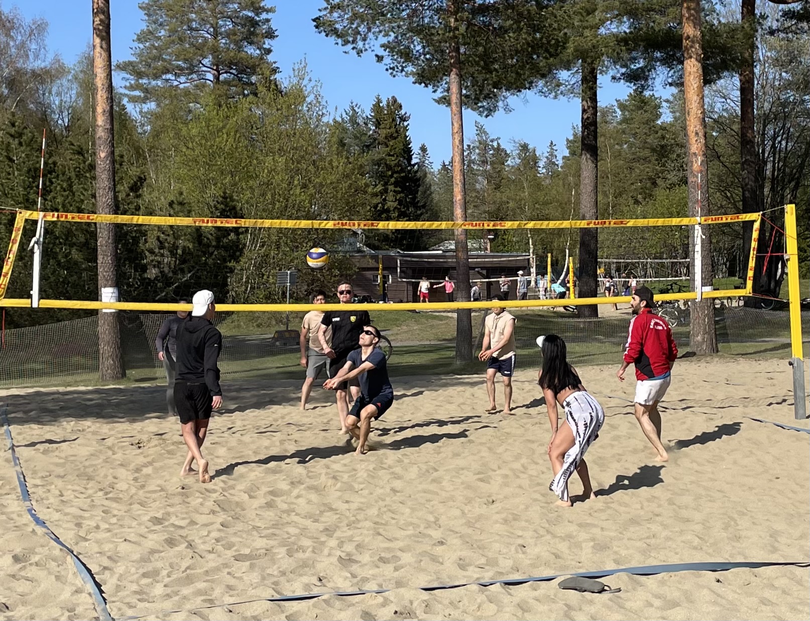 Några ungdomar som spelar beachvolleyboll på sand